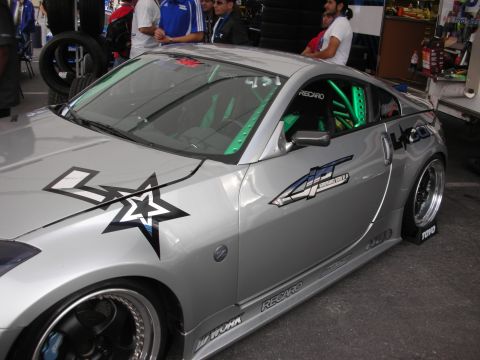 1998 Ford Crown Victoria - A silver sports car with custom decals and racing modifications is parked outdoors.