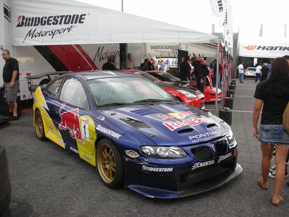 Blue Pontiac GTO Red Bull race car under Bridgestone tent