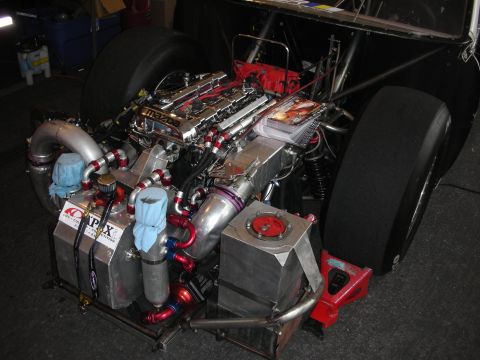 1998 Ford Crown Victoria - Custom Mazda engine assembly with prominent turbochargers and intricate plumbing, likely for a racing application.