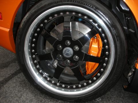 1998 Ford Crown Victoria - A custom wheel with an orange brake caliper is shown on an orange vehicle.