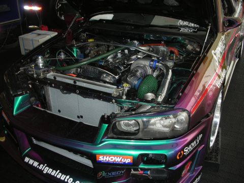 1998 Ford Crown Victoria - The engine bay of a highly modified import car, a large turbocharger and custom iridescent paintwork.