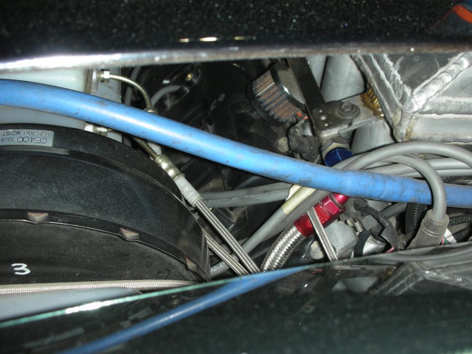 Engine bay detail with blue hose, braided lines and number 3