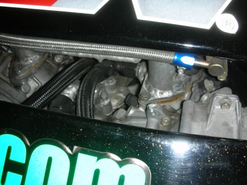 1998 Ford Crown Victoria - Close-up view of engine components and braided hoses within a vehicle's engine bay.