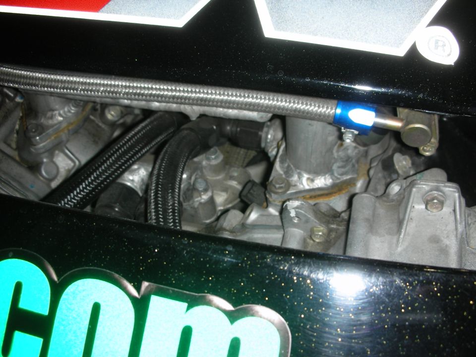 Engine detail with braided lines over a green decaled fender