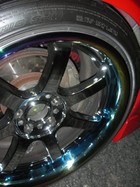 1998 Ford Crown Victoria - A close-up shot focuses on a custom chrome wheel, its intricate design and the tire's tread.