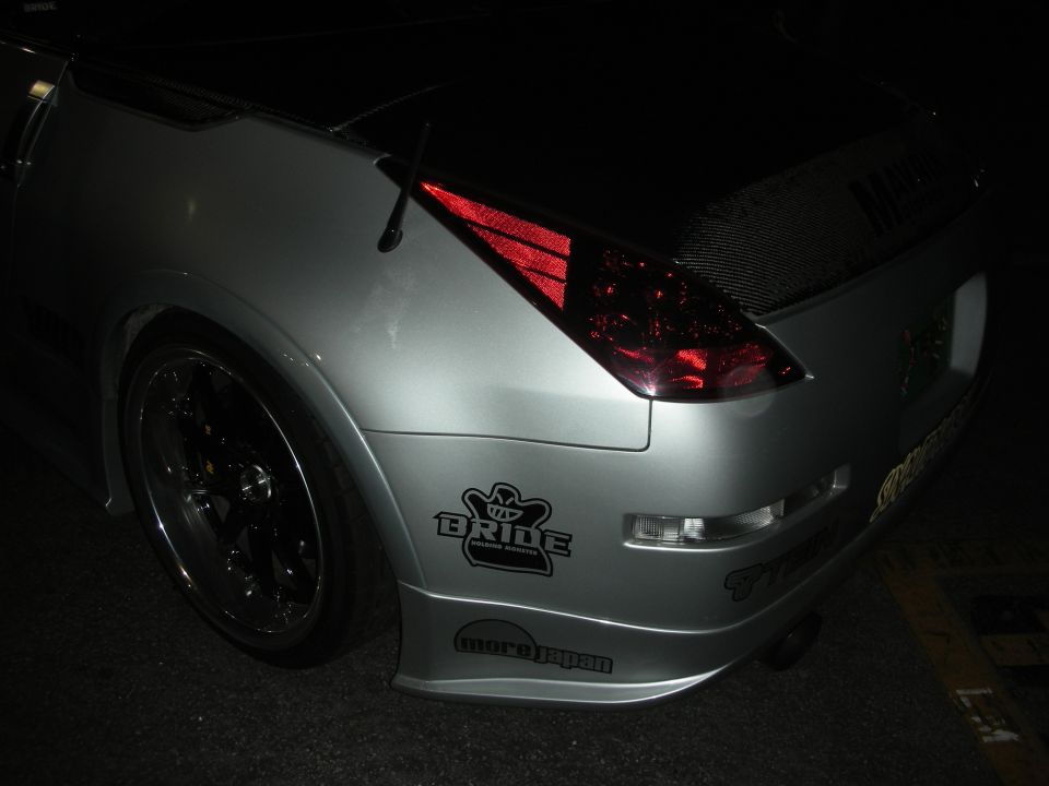 Rear quarter of silver Nissan 350Z with Bride decal at night