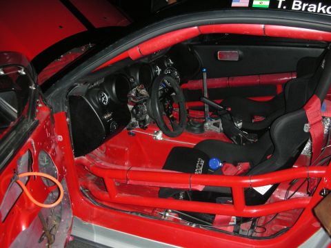 1998 Ford Crown Victoria - The interior of a modified red car shows racing seats and a roll cage, indicating a focus on performance.