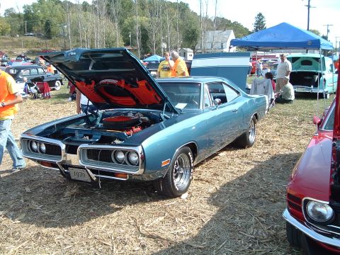 2001 Ford Taurus - A blue 1970 Dodge Super Bee is displayed with its hood open at an outdoor car show.