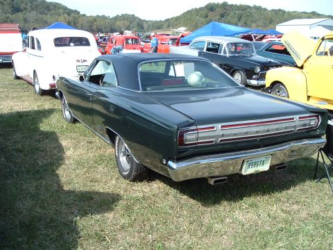 2001 Ford Taurus - A dark green coupe with a black vinyl roof is parked on grass at an outdoor car show.