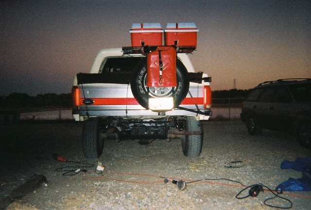 Rear view of a 1991 Ford Bronco with a spare tire, two coolers, and a red gas can mounted on the back