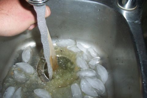 1994 Ford F-150 - Ice and water in a sink basin, with water flowing from a faucet into the drain.