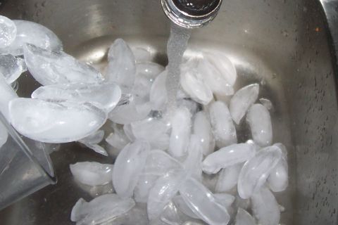 1994 Ford F-150 - Ice cubes are being rinsed in a sink under running water.