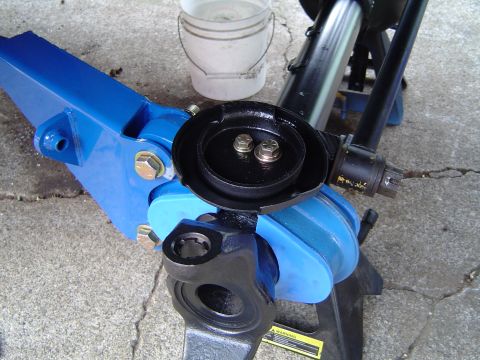 1978 Ford Bronco - A vehicle's front axle assembly is shown with a blue jack and jack stand supporting it.
