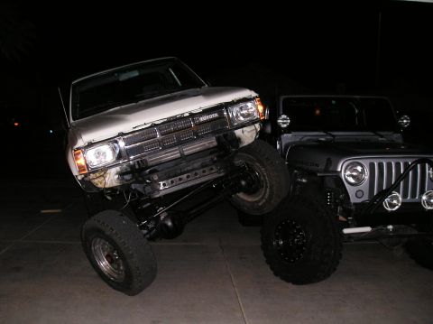1986 Toyota Hilux - A white 1986 Toyota Hilux is shown with a lifted suspension, parked next to a Jeep.