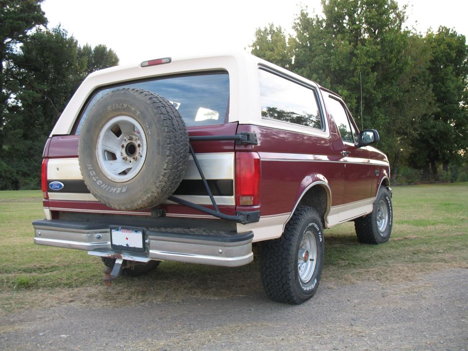 Maroon and tan Ford Bronco rear view with spare tire carrier