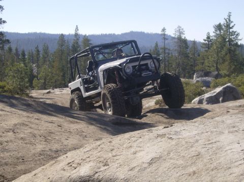 1986 Ford Bronco - This modified Toyota Land Cruiser FJ40 navigates a rocky trail with significant suspension articulation.