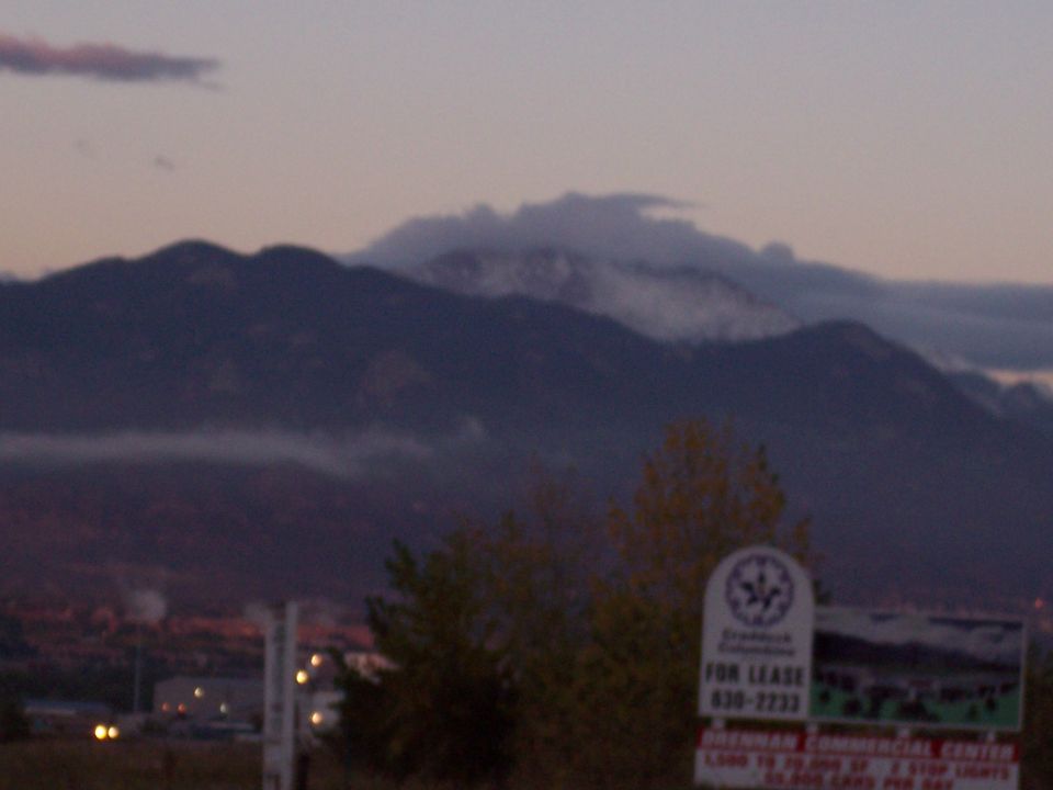 Mountains at dusk with a "For Lease" sign in the foreground