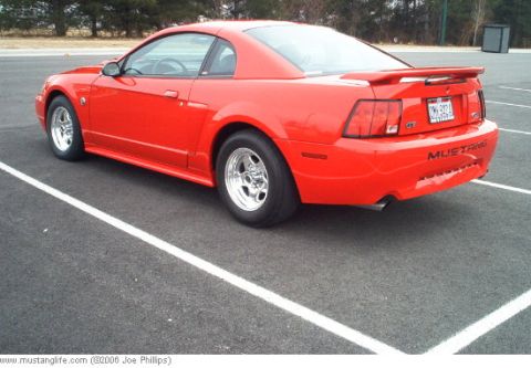 2004 Ford Mustang - This red 2004 Ford Mustang GT is shown from the rear in a parking lot.