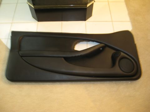 2002 Pontiac Trans Am - A black car door panel is shown, with a visible speaker grille and armrest.