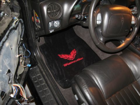 2002 Pontiac Trans Am - Interior view of a 2002 Pontiac Trans Am, showing the driver's seat, steering wheel, and dashboard with custom floor mats.