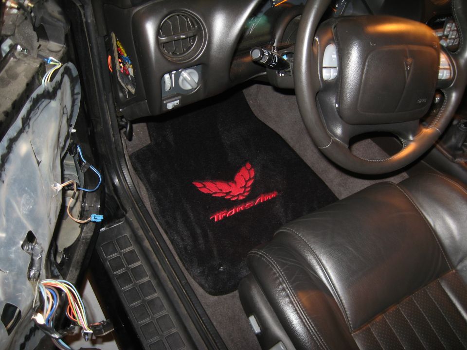Black leather seats and floor mats with red Trans Am bird logo inside a 2002 Pontiac Trans Am