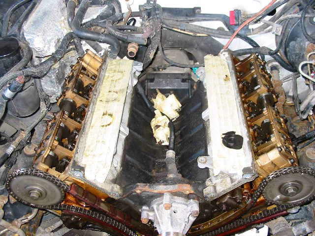 Engine with valve covers removed, showing timing chains and internal components