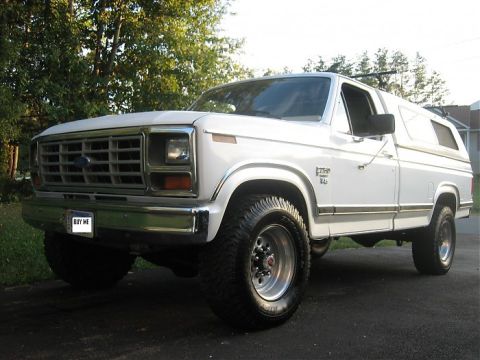 1984 Ford F-250 - This white Ford Bronco is equipped with a camper shell and aftermarket wheels.