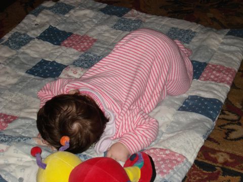 2000 Ford Crown Victoria - A baby sleeps on a quilt, surrounded by toys.