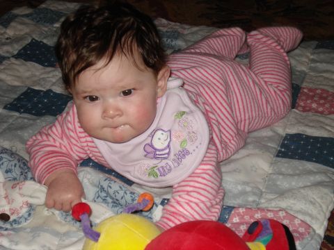 2000 Ford Crown Victoria - Baby in striped pajamas and a bib lies on a quilt with toys.