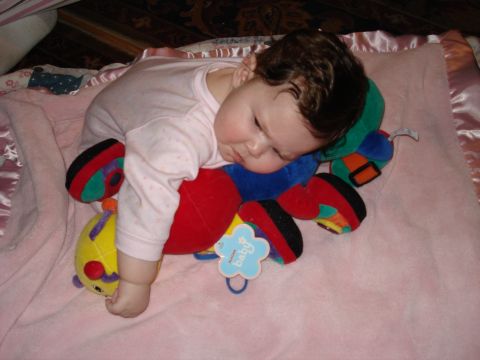 2000 Ford Crown Victoria - A baby rests peacefully on a plush caterpillar toy, on a pink blanket.