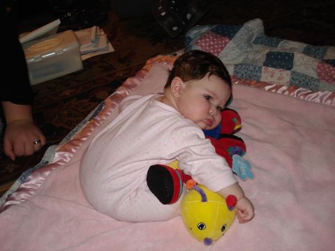 2000 Ford Crown Victoria - Baby lies on a pink blanket with stuffed toys, with a quilt in the background.