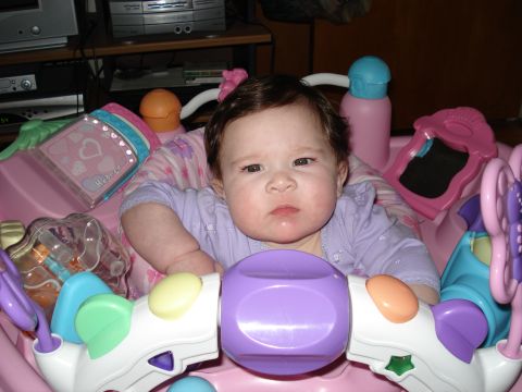 2000 Ford Crown Victoria - A baby sits in a pink activity center surrounded by toys.