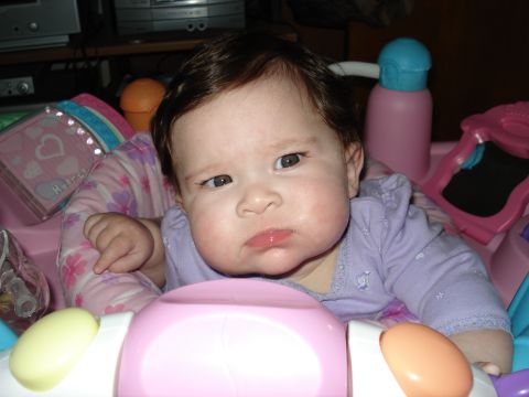 2000 Ford Crown Victoria - A baby is pictured in a pink activity center, surrounded by toys and play items.