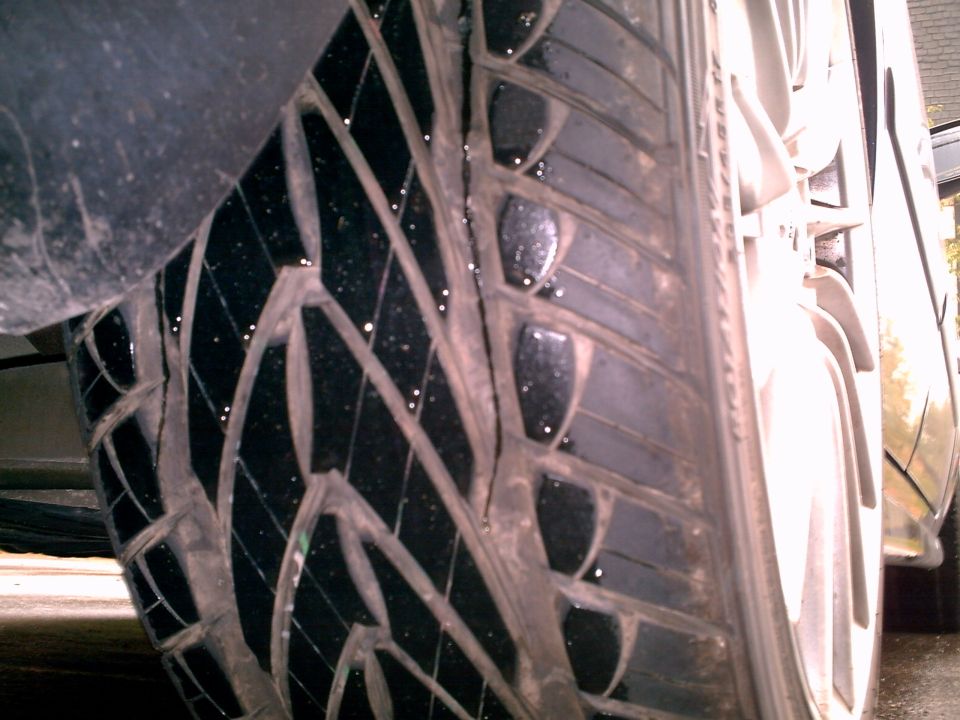 Close-up of wet directional tire tread on an alloy wheel
