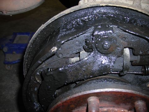 1995 Ford F-250 - Close-up of a heavily soiled and worn brake assembly, indicating a need for maintenance.