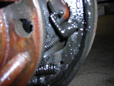 1995 Ford F-250 - Close-up view of a greasy brake drum assembly, showing springs and brake shoes.