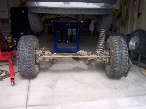 1995 Ford Bronco - Vehicle's front axle and suspension components are visible while it is elevated on a lift.