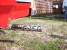 1989 Ford Bronco - A vehicle emblem rests on the grass, with a red object and a brick wall in the background.