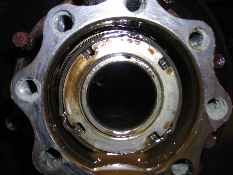Close-up of open 8-lug front hub showing spindle nut, tab washer and oily bearing race