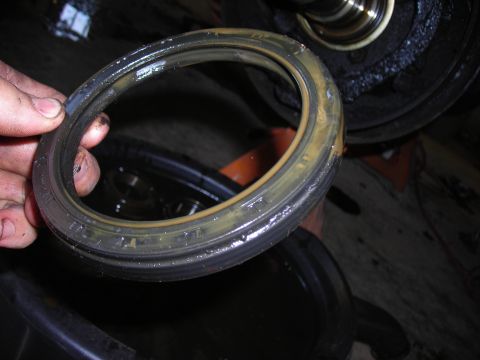 1995 Ford F-250 - A person holds a used oil seal, showing signs of wear and grease.
