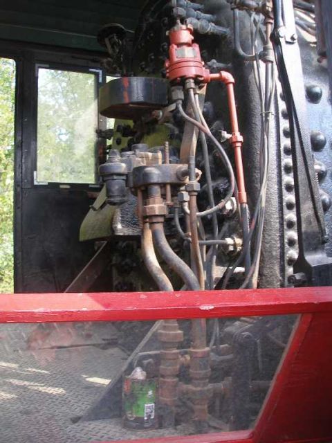 1998 Ford Crown Victoria - Cab-side controls of a steam locomotive, showing red-painted valves and piping, gauges and a heavily riveted boiler backhead, framed by the…