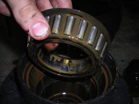 1995 Ford F-250 - A mechanic inspects a used wheel bearing, likely for a Ford F-250.