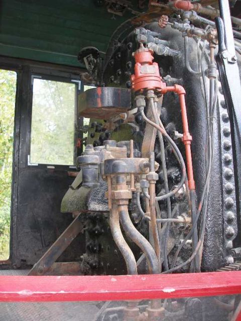 1998 Ford Crown Victoria - Inside the cab of a steam locomotive, looking at the riveted backhead with its maze of copper and steel plumbing, brass valves and a red-pa…