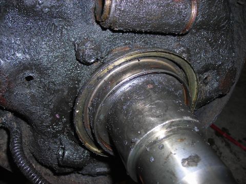 1995 Ford F-250 - Close-up of a greasy differential axle seal and shaft, likely needing replacement.
