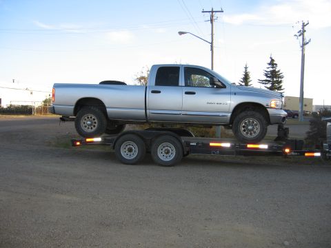 2005 Dodge 3500 - Silver 2005 Dodge Ram 2500 pickup truck loaded onto a trailer for transport.