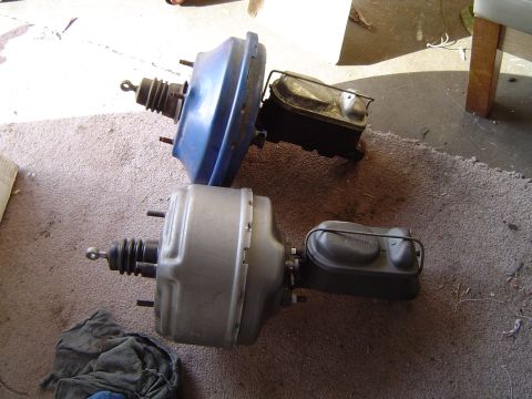 1978 Ford Bronco - Two automotive brake boosters and master cylinders are shown, one blue and one silver.