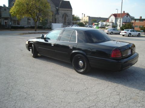2000 Ford Crown Victoria - This black 2000 Ford Crown Victoria sedan is shown from a three-quarter front perspective.