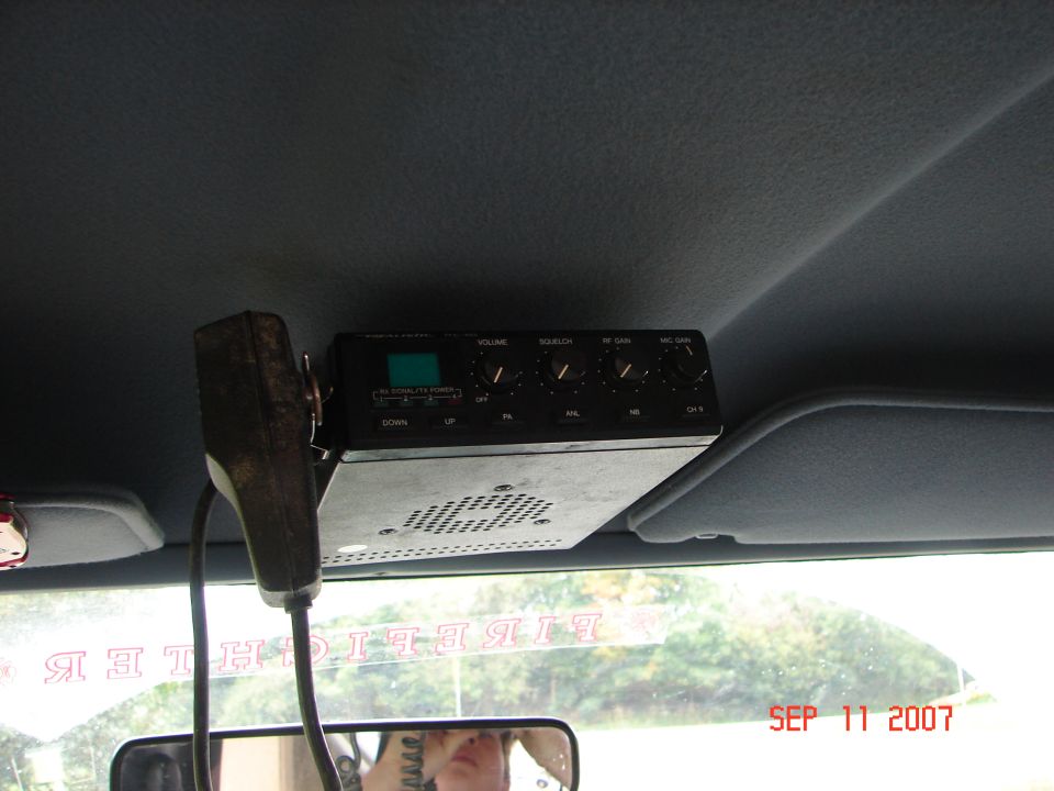 CB radio mounted to a vehicle headliner with a microphone