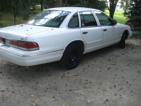 1997 Ford Crown Victoria - A white 1997 Ford Crown Victoria is seen from the rear quarter angle, parked outdoors.