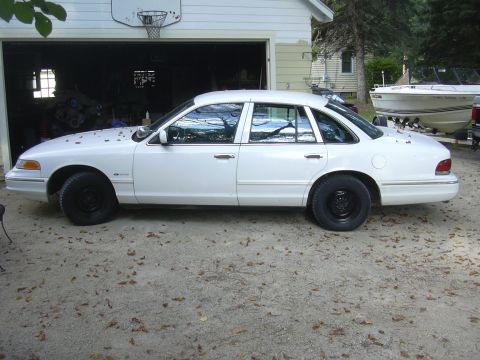 1997 Ford Crown Victoria - White 1997 Ford Crown Victoria parked in a driveway with a boat on a trailer nearby.